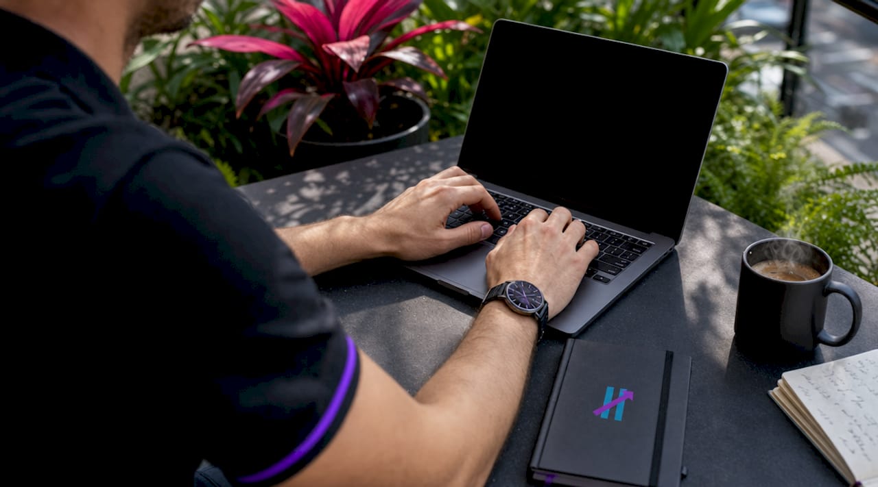 Hands typing on laptop with notes nearby