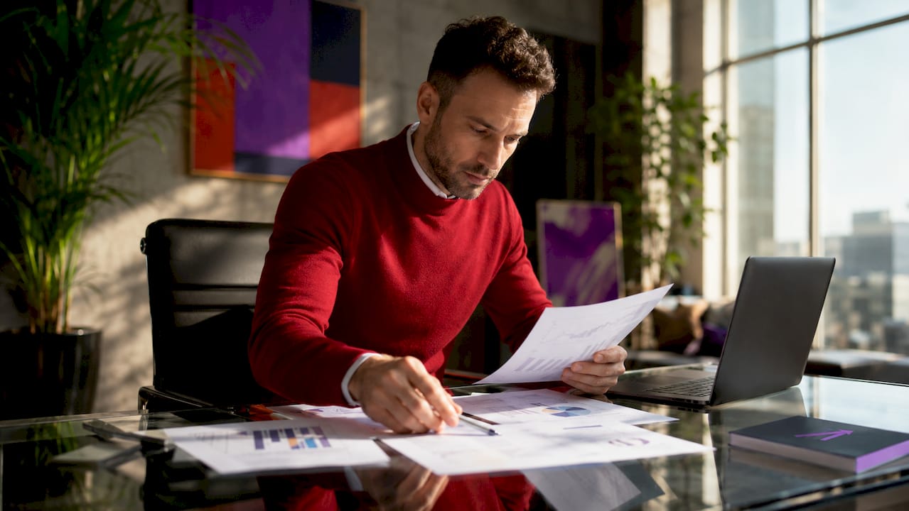 Trader reviewing printed buy and sell signal charts