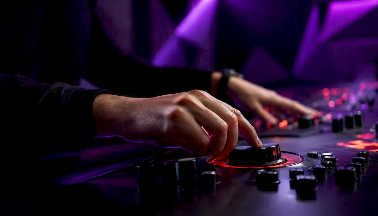Hands tuning indicator controls in moody light