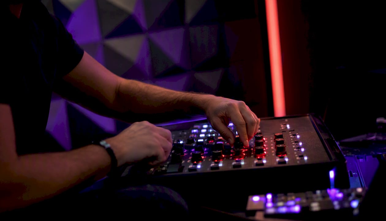 Hands tuning trading controls in dark studio