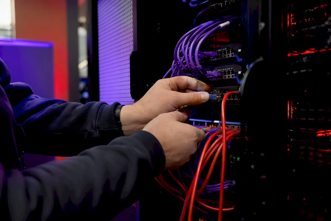 Hands securing cables in server rack