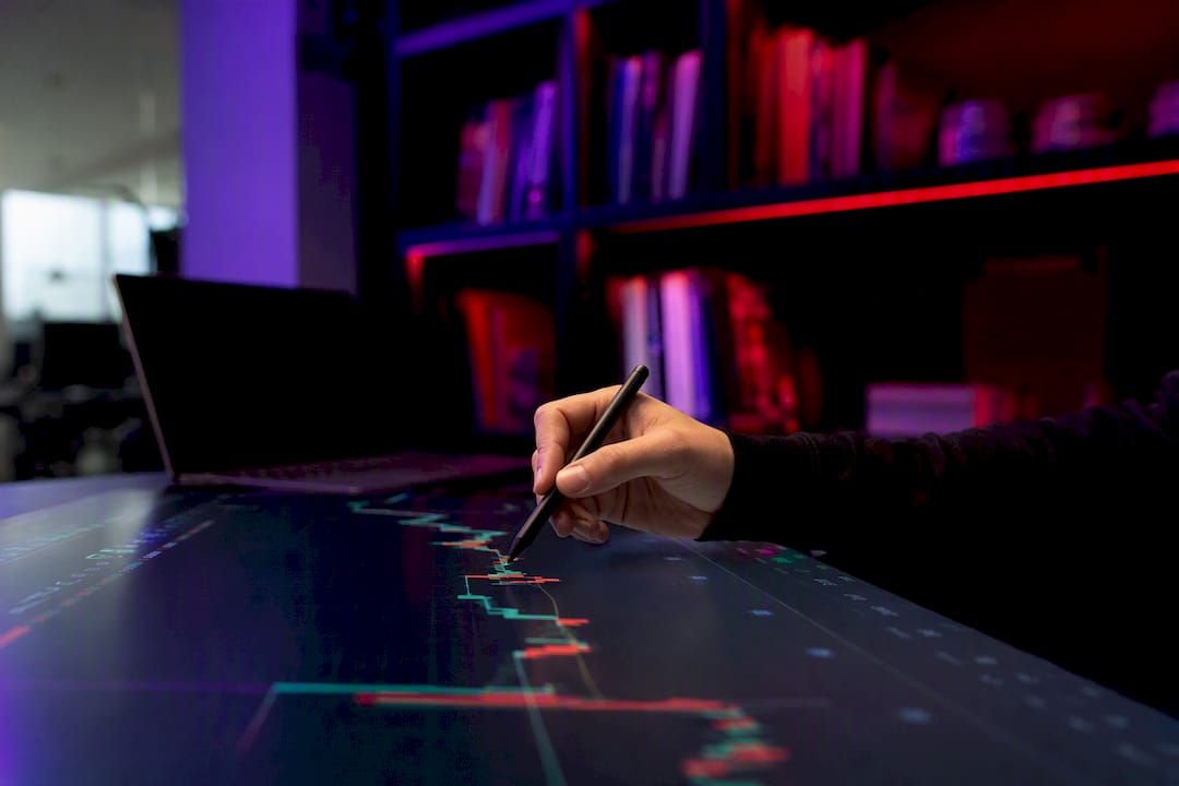 Hands pointing at trading chart details