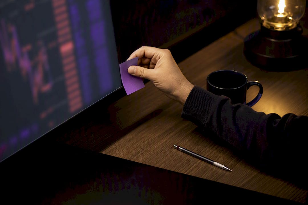 Trader placing emotional control plan beside monitor