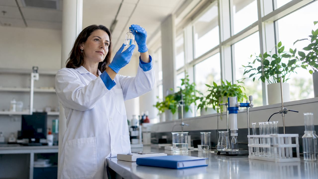 Scientist holding vial of hydrogen water in lab