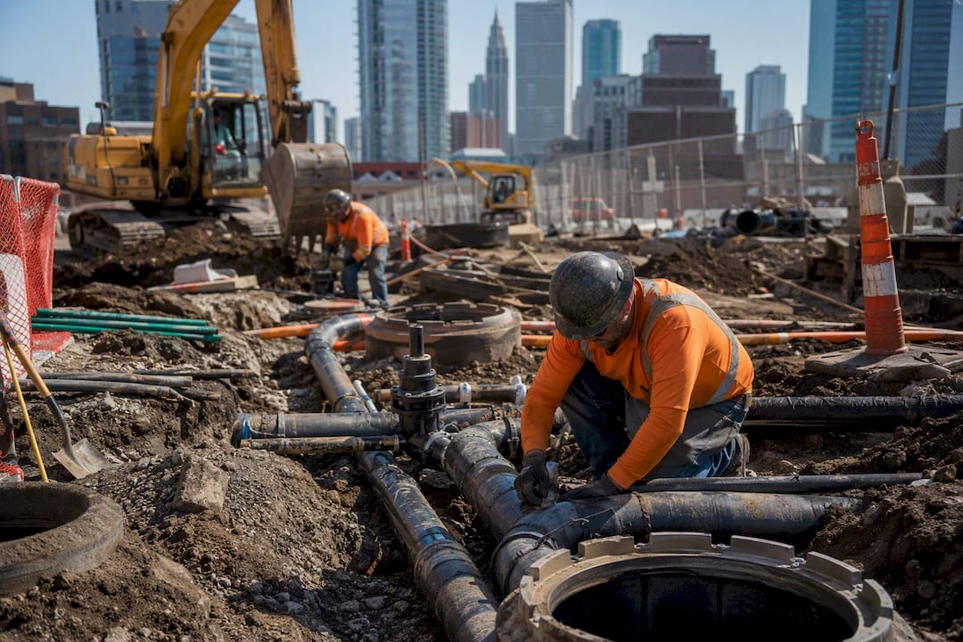 Utility pipes and workers installing underground