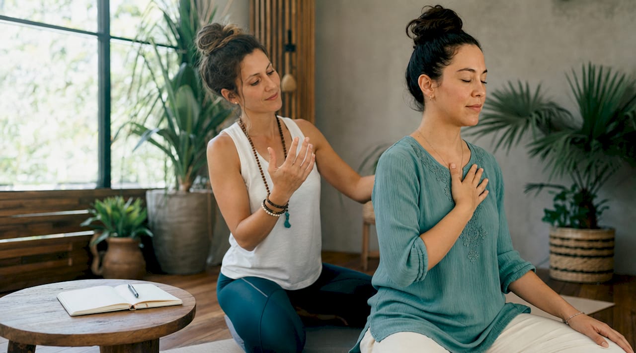 Hands guiding breathwork in healing garden