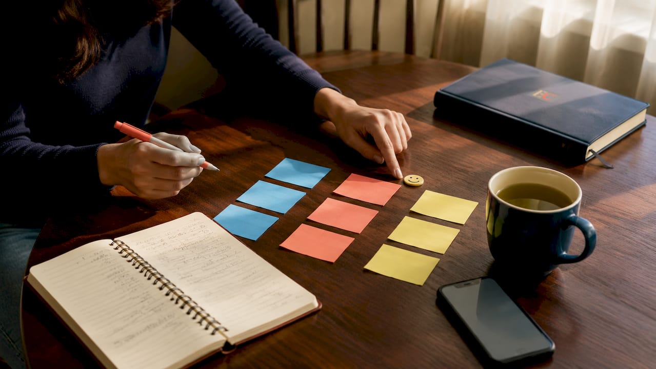 What is a family financial plan: a Singapore guide 2 Hands organizing budgeting notes on desk