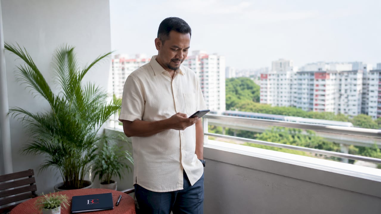 How to save money on rent in Singapore: 2026 guide 3 Man on HDB balcony considering rent savings options