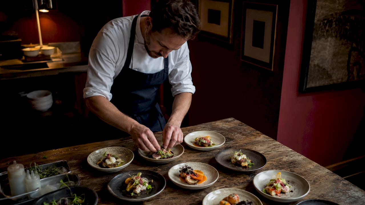 Chef plating small plates in kitchen