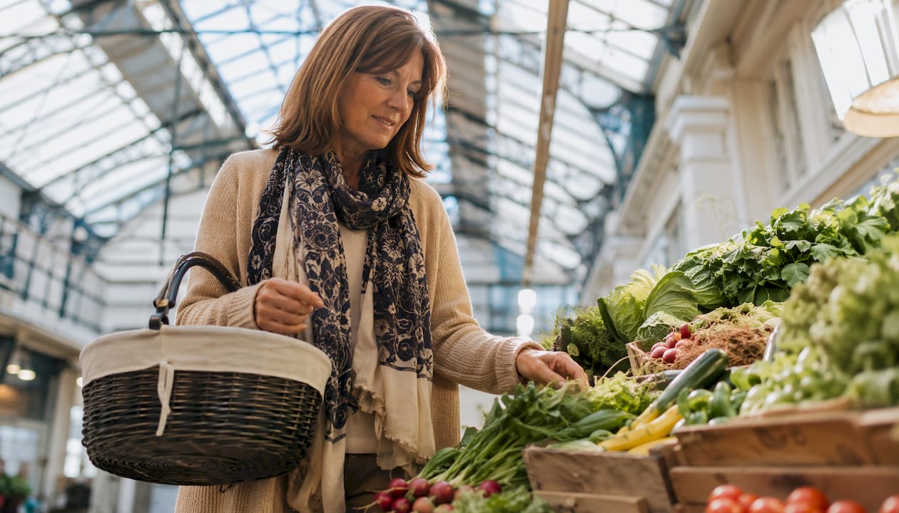 Woman selecting vegetables at market stall