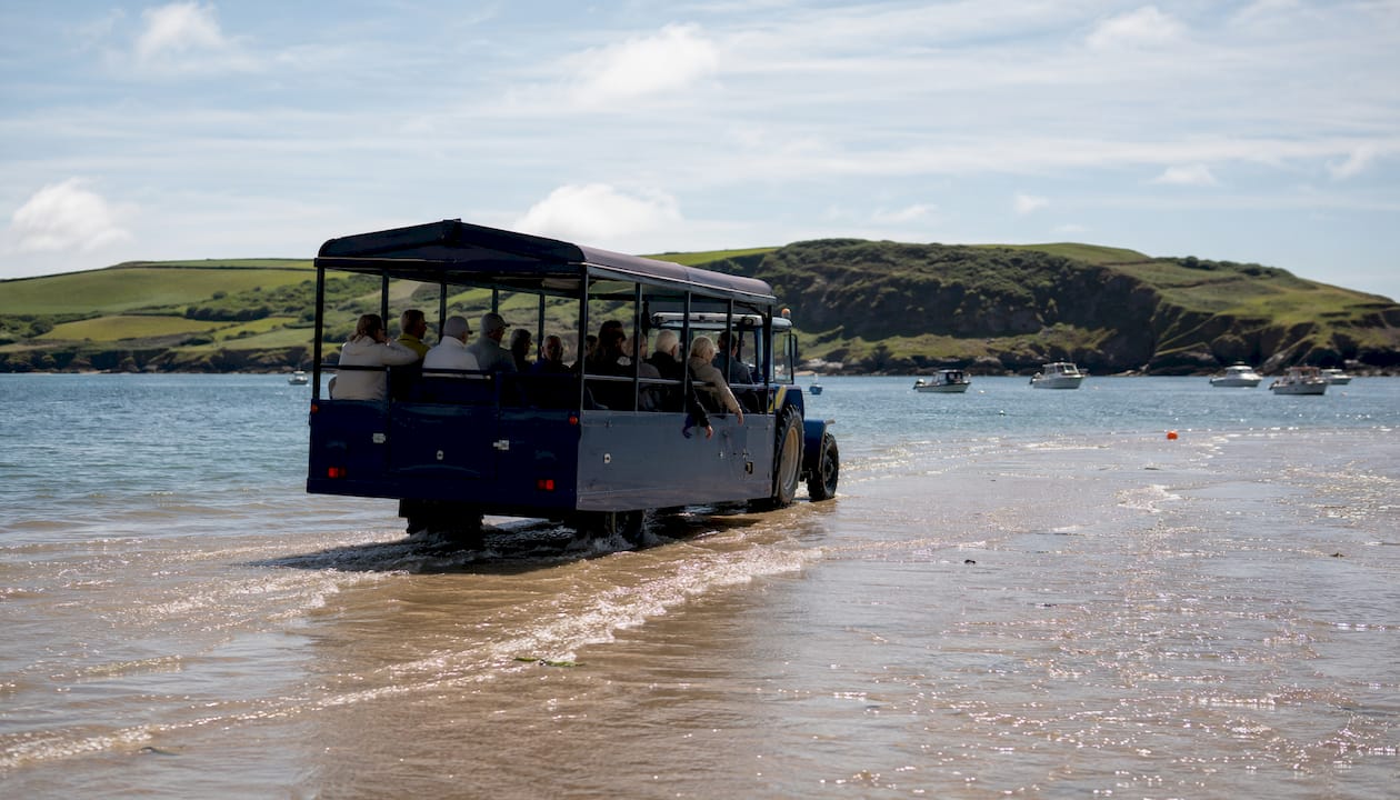 Sea tractor crossing tidal causeway with passengers