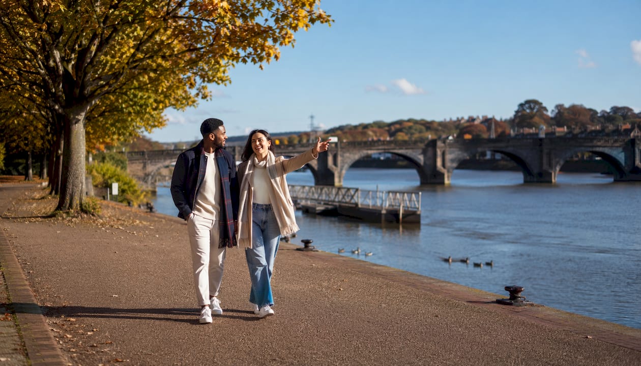 Couple walking riverside near Barnstaple Long Bridge