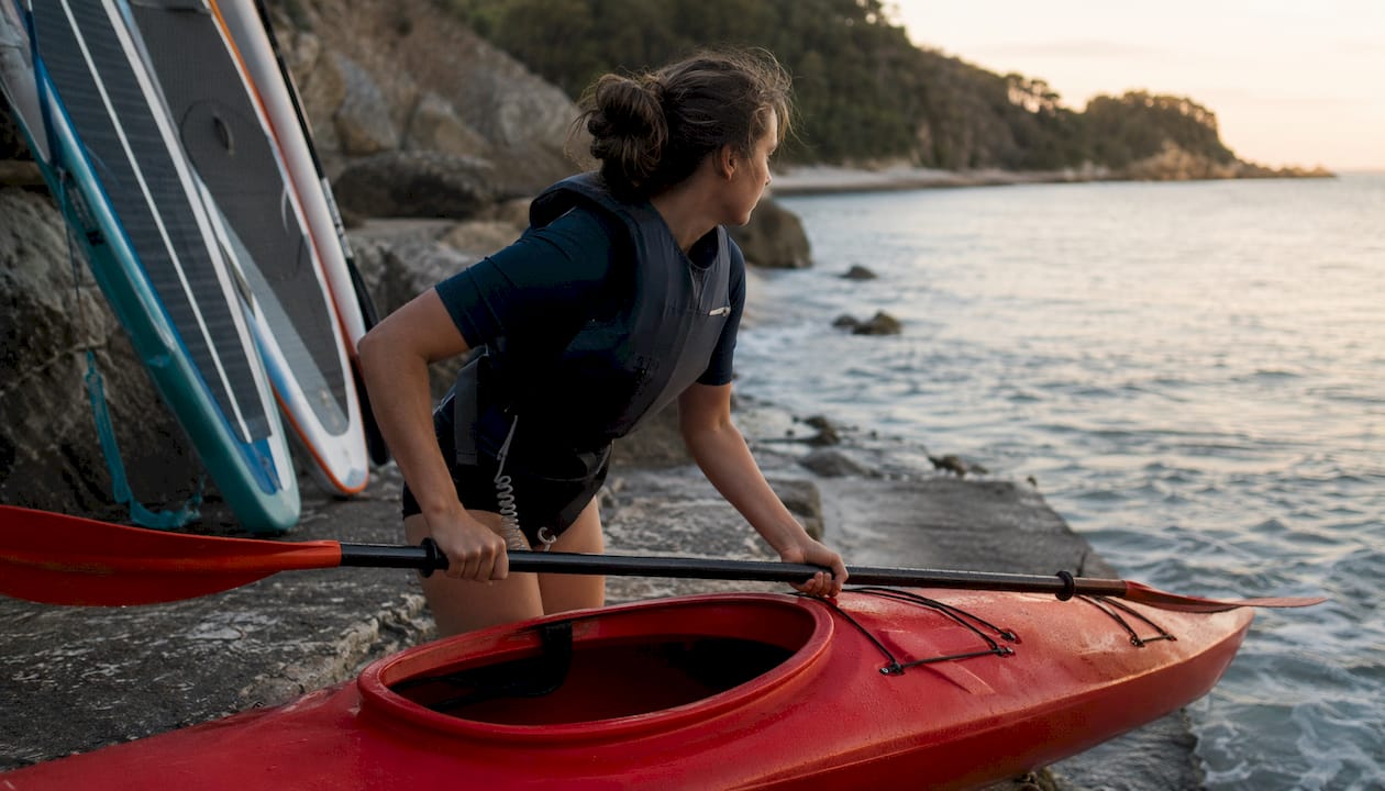 Woman launching kayak on Blackpool Sands