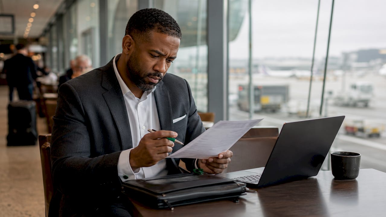 Businessman reviewing travel itinerary in lounge