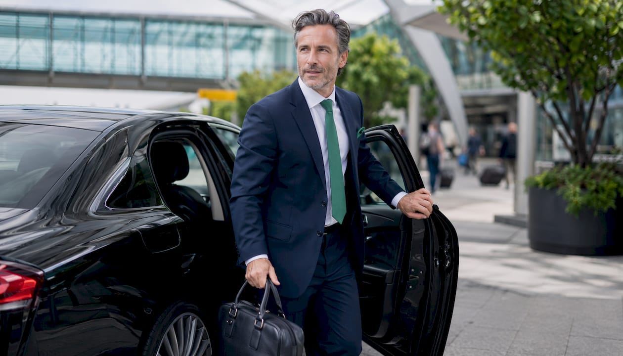Man exiting luxury car at European airport
