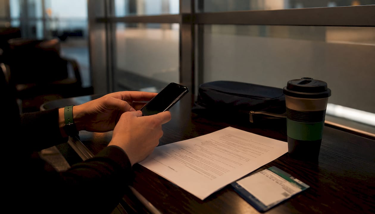 Overhead view of cancellation policy document and smartphone on café table