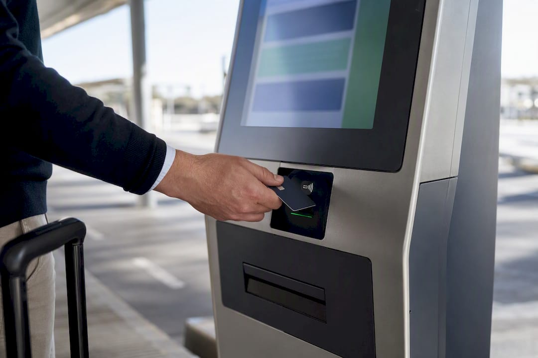 Traveler tapping card at airport ticket machine