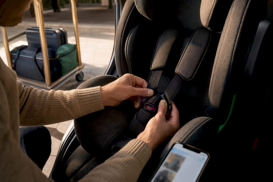 Hands checking a child restraint harness