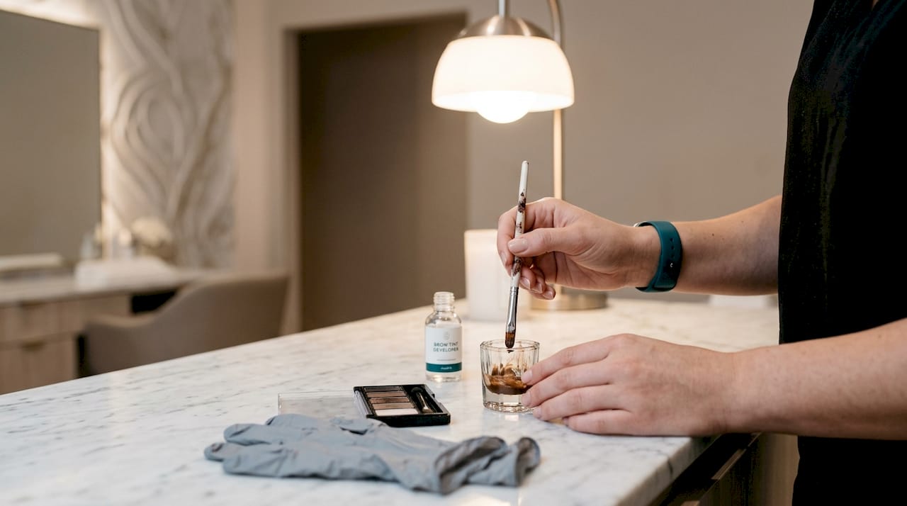 Beautician preparing brow tint chemicals