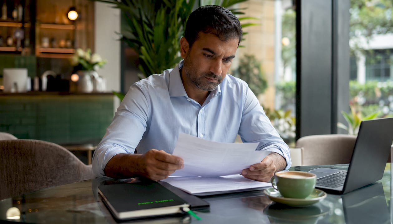 Man reviewing franchise agreement at table