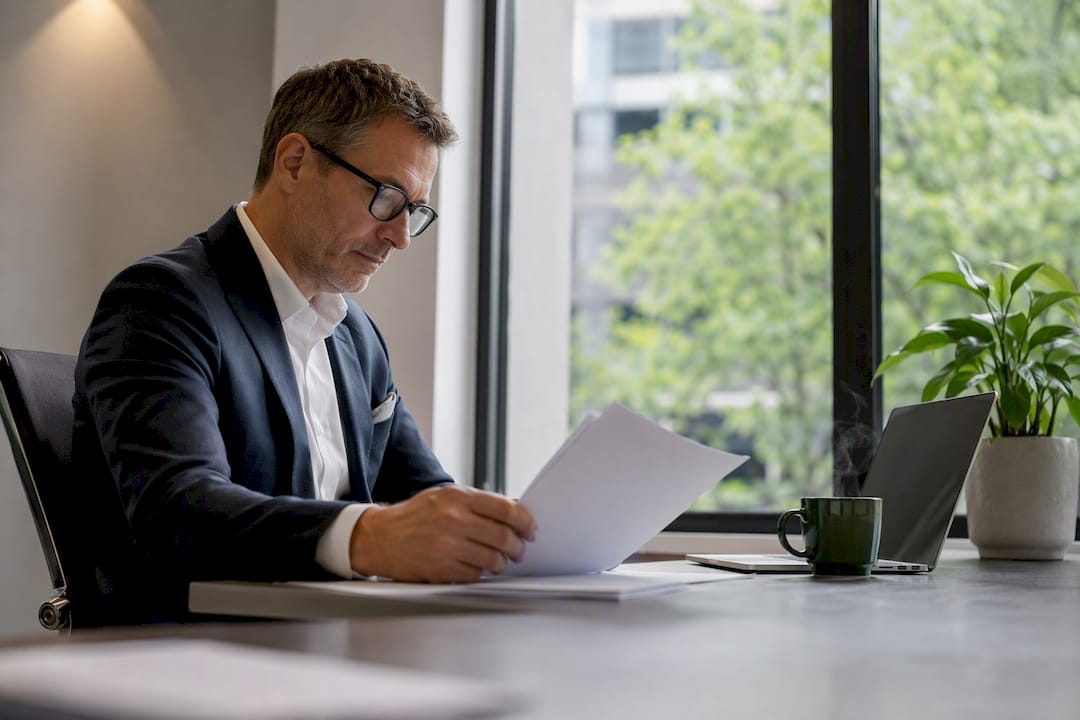 Executive reviewing financial portfolios at office desk