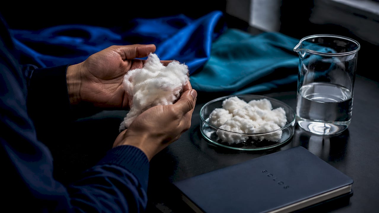 Close-up hands holding moist cotton fibres