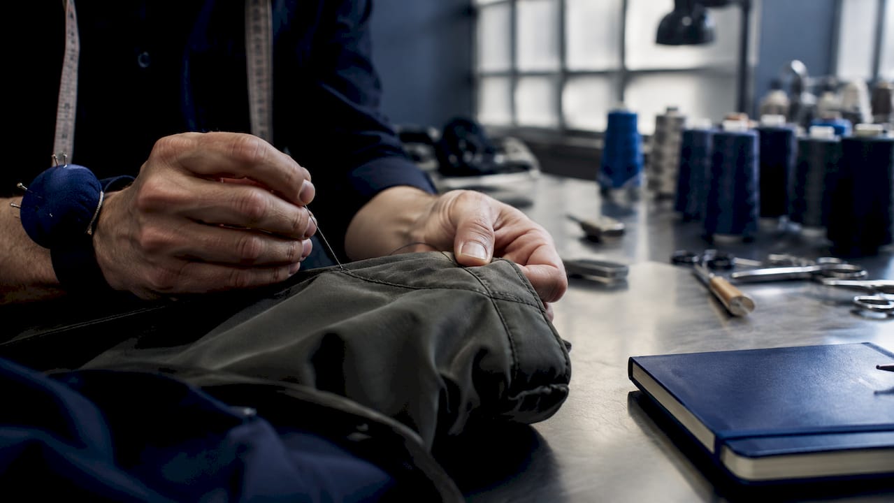 Tailor sewing reinforced seam on durable garment
