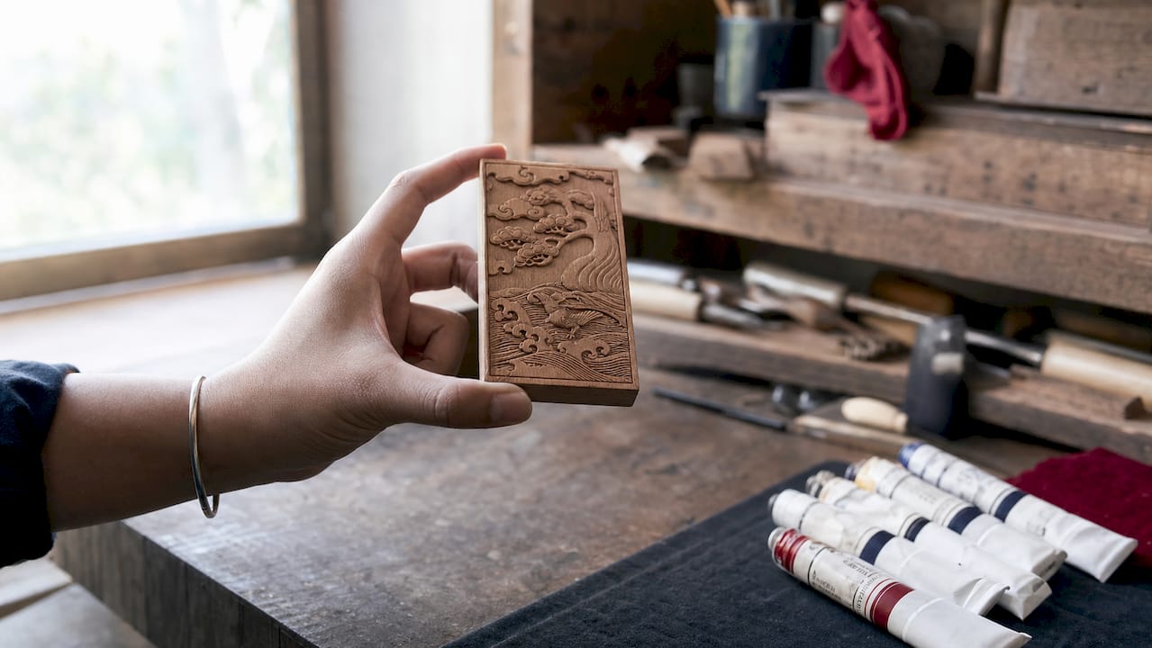 Close-up of hand holding raised etched wooden plaque