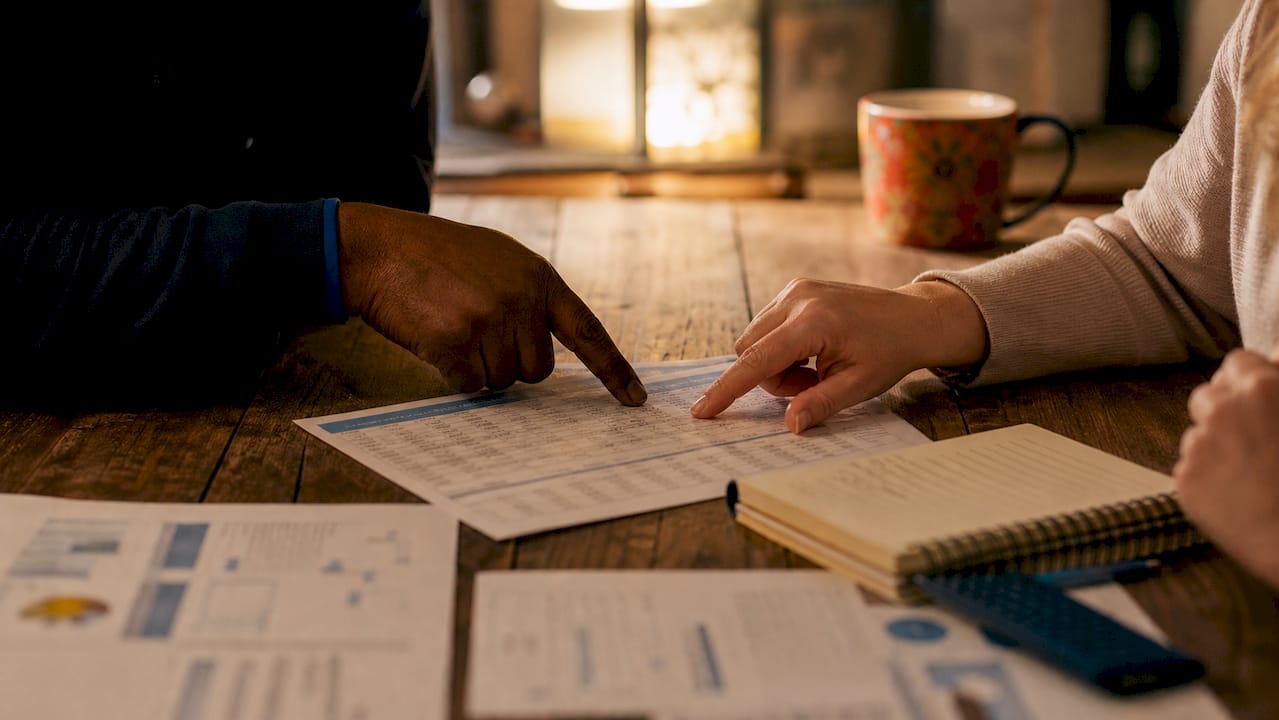 Hands pointing at auto loan interest table