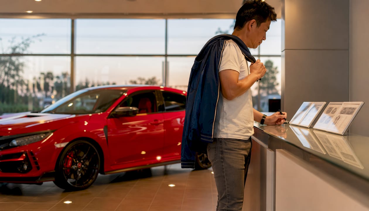 Man studying Honda Civic Type R details in showroom