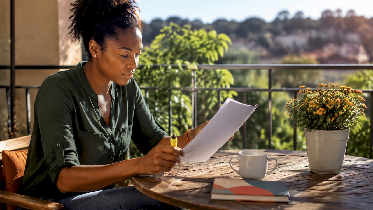 Woman reviewing renters insurance document at kitchen table