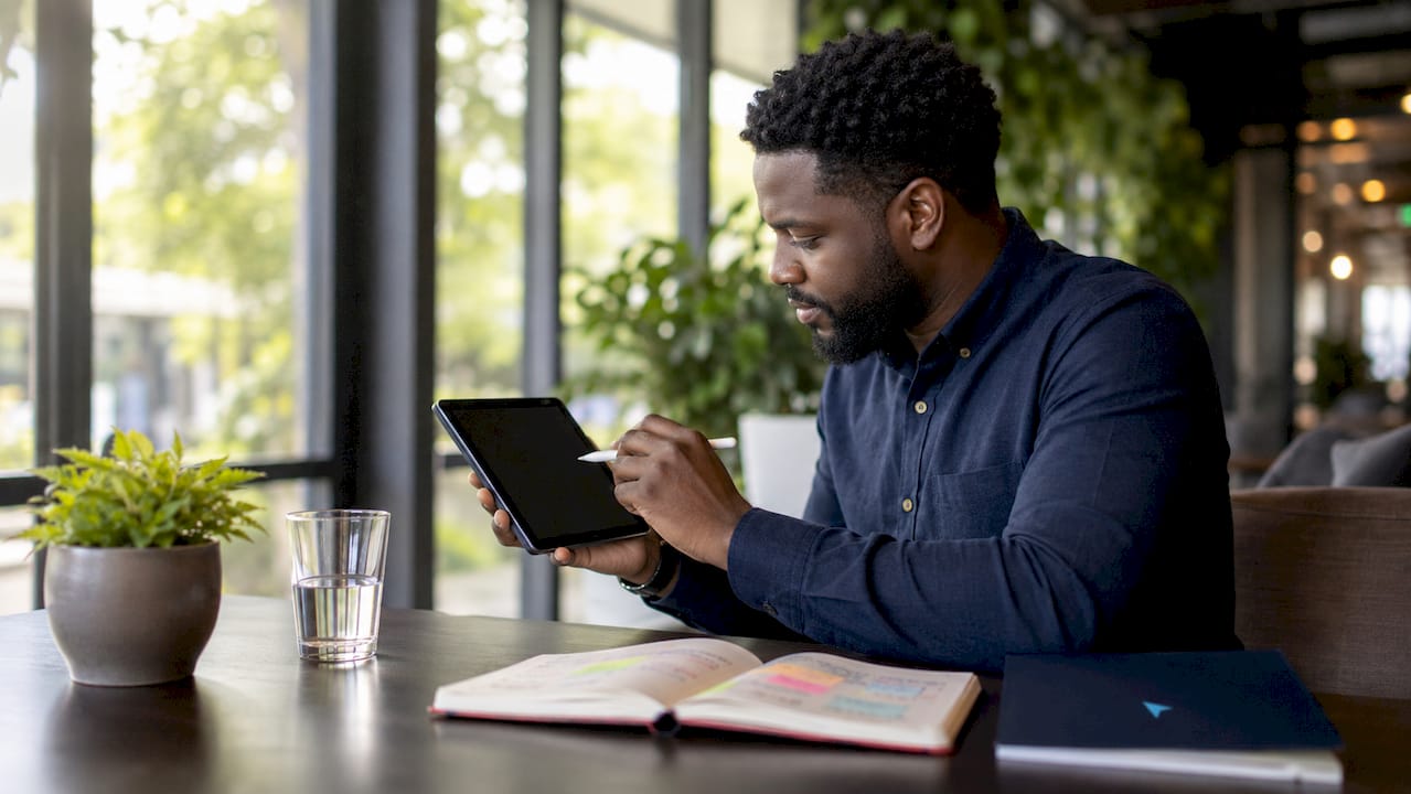 Marketer analyzing brand differentiation on tablet in cafe