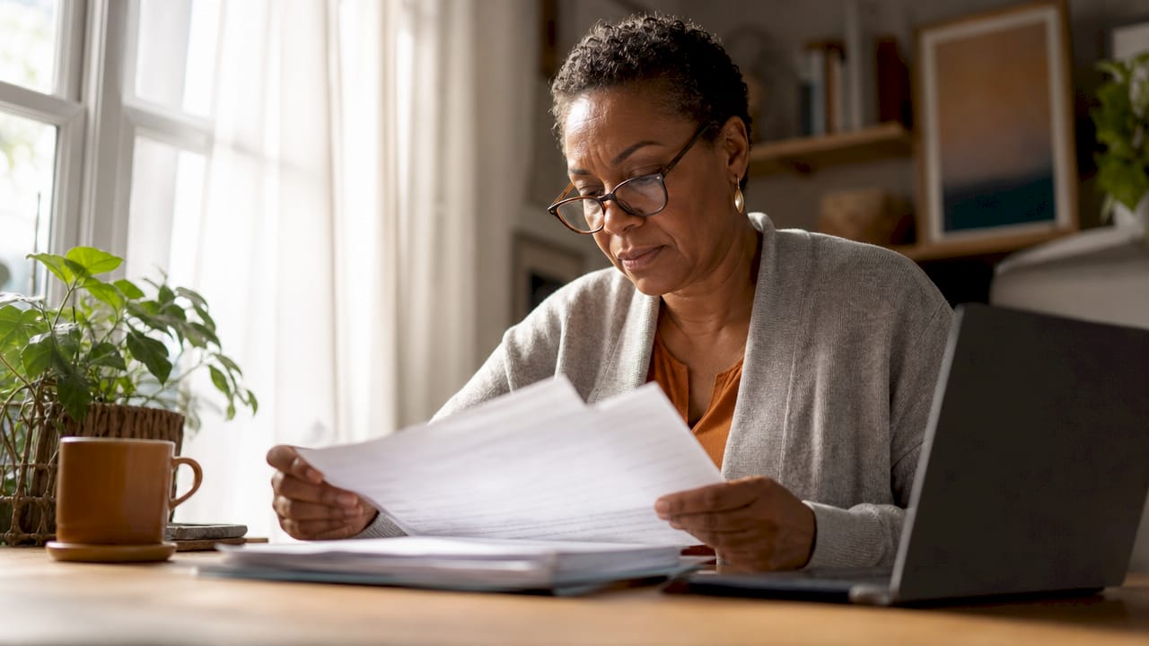 Woman reviewing insurance claim papers at home