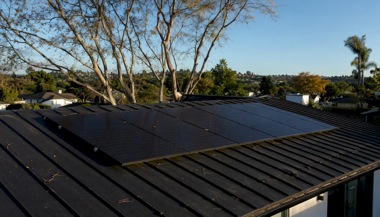 Close-up of roof shingles under solar panels