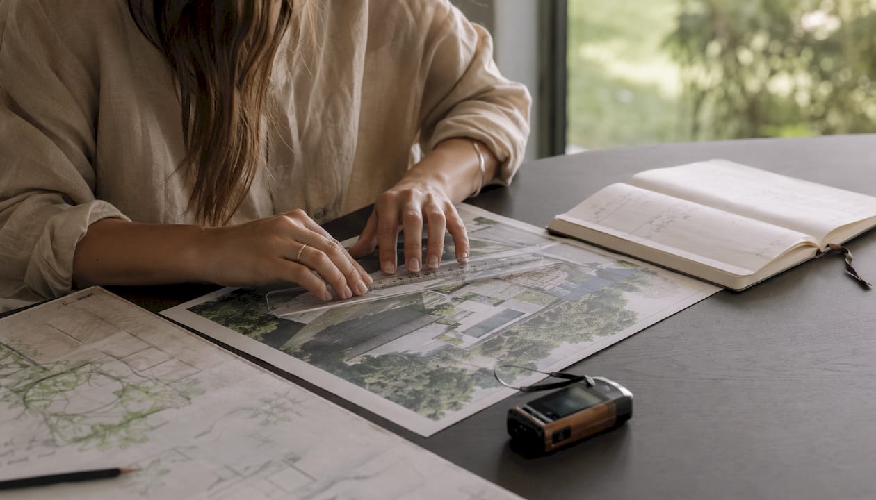 Hands measuring printed 3D landscape rendering with scale ruler