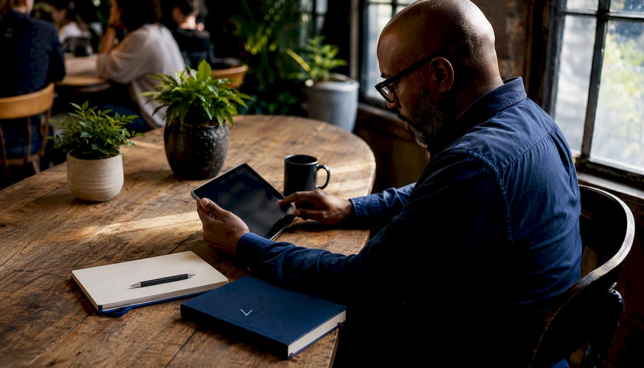 Man reviewing email platforms on tablet in coworking space