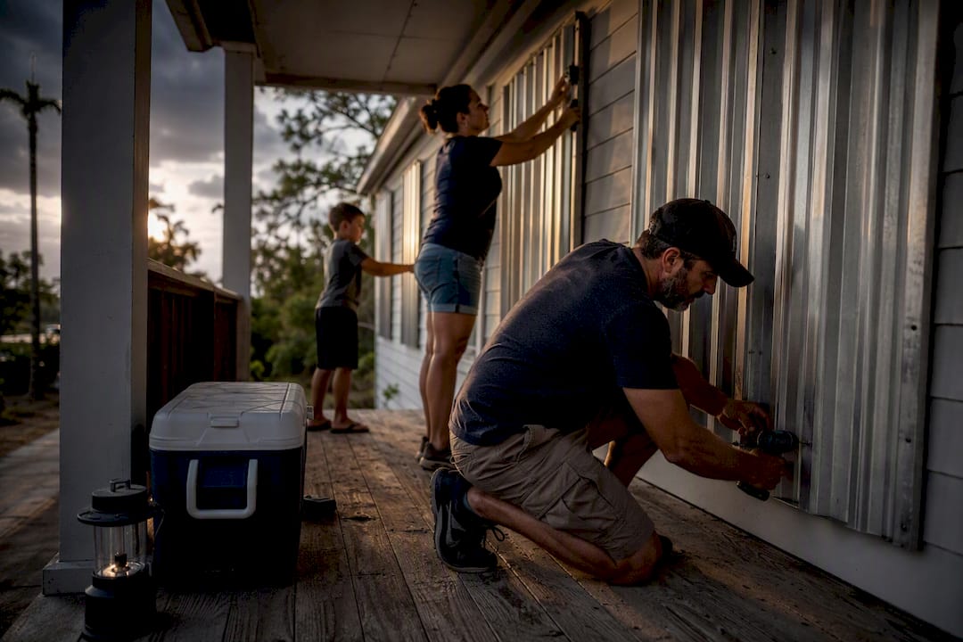 Family securing home before hurricane evacuation