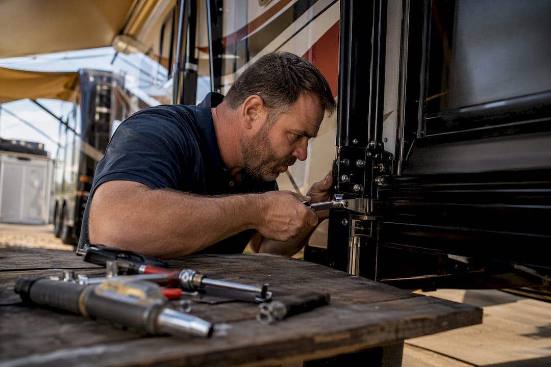 Technician repairing RV slide-out in service bay