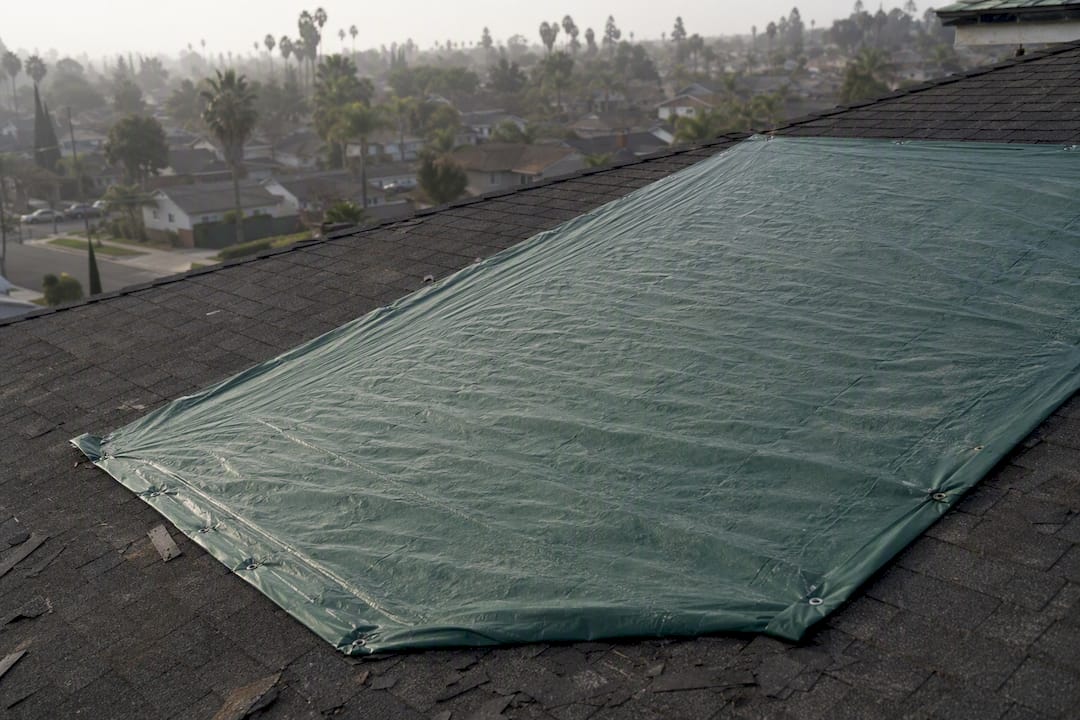 Large tarp neatly secured over roof opening
