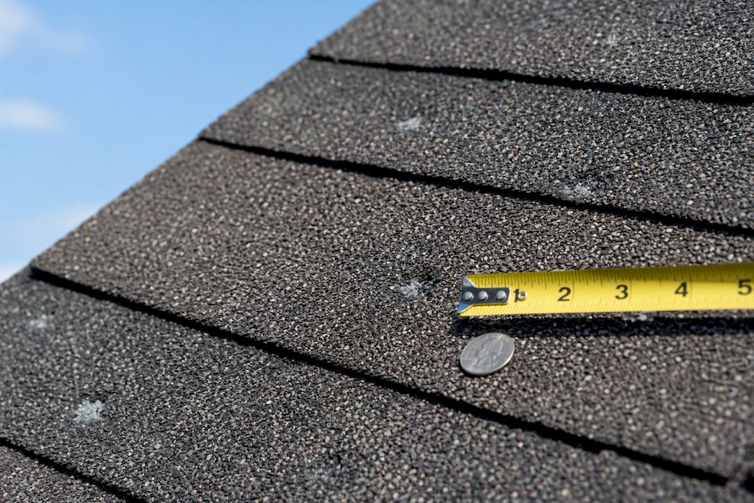 Hail damage on roof with ruler and coin scale