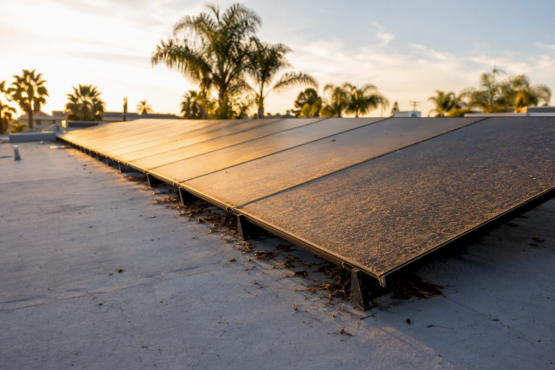 Dust and debris on flat roof solar panel edge