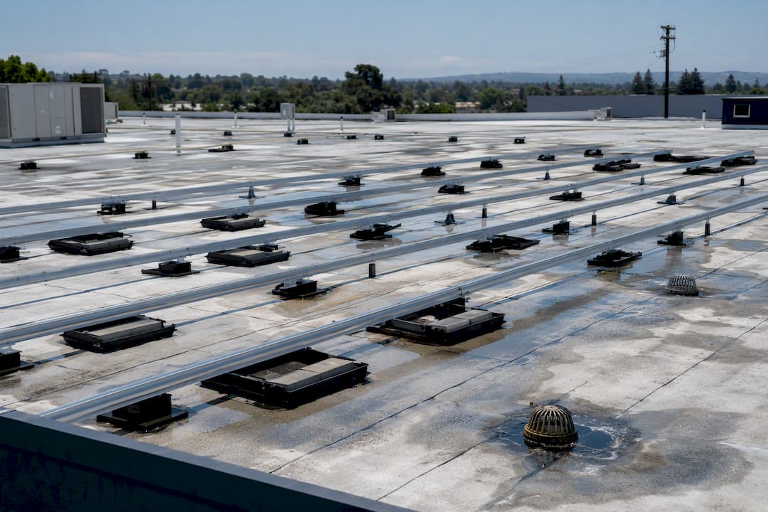 Pooled water on flat roof around solar mounting trays