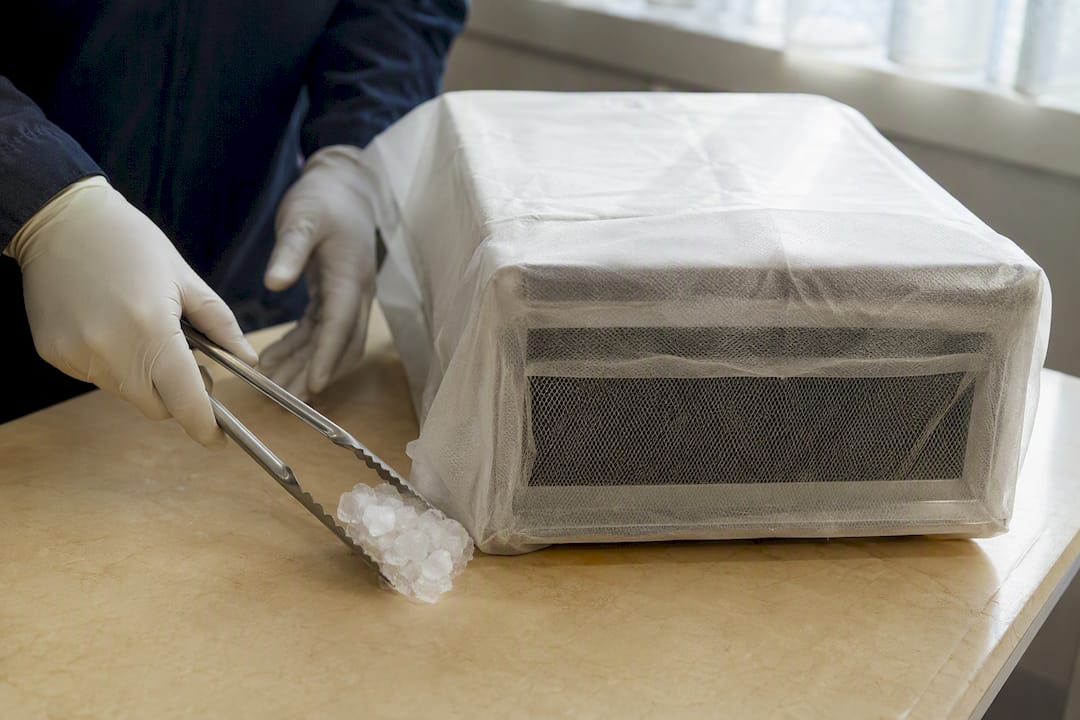 Gloved hands handling dry ice safely
