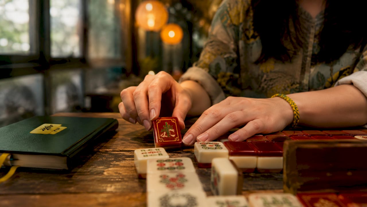 Close-up of hands on open Mahjong tile