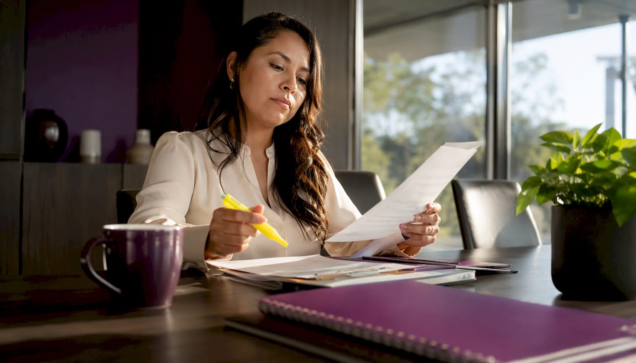 Woman reviewing certification papers at construction office