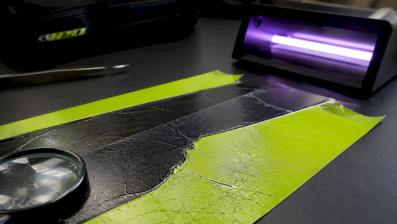 Close-up of UV damaged vinyl samples with tools