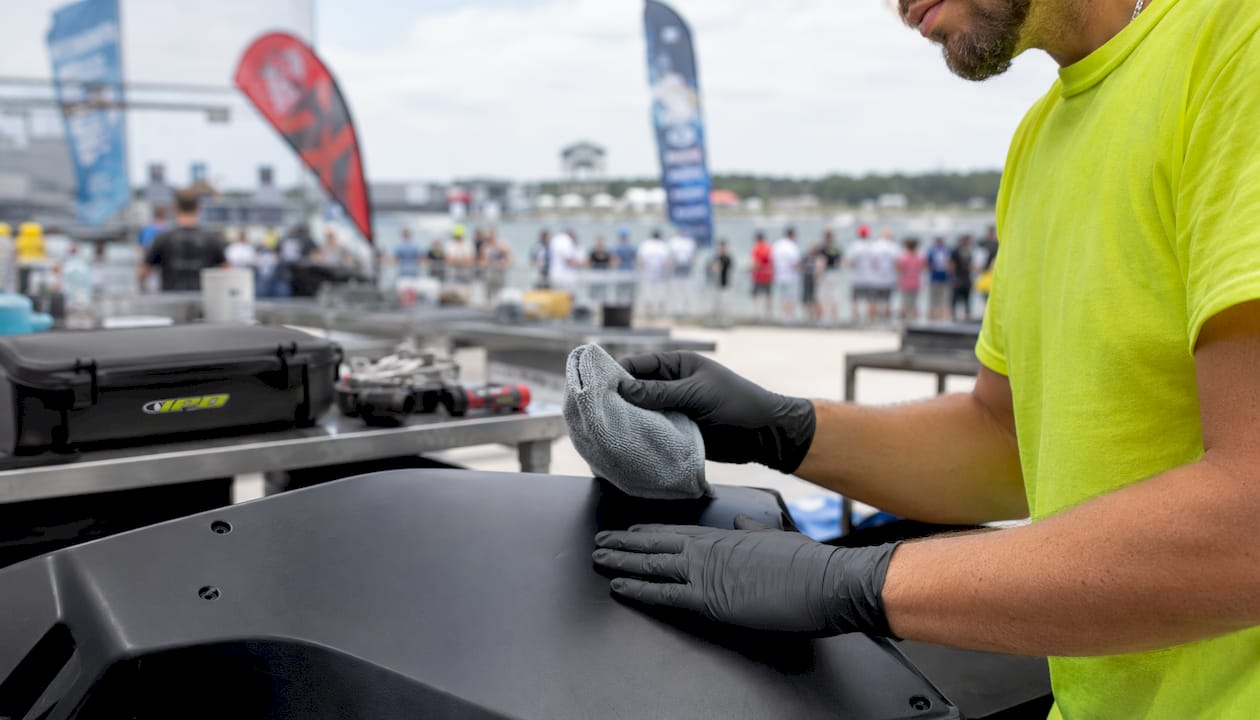 Close-up of hands cleaning matte race bike panel