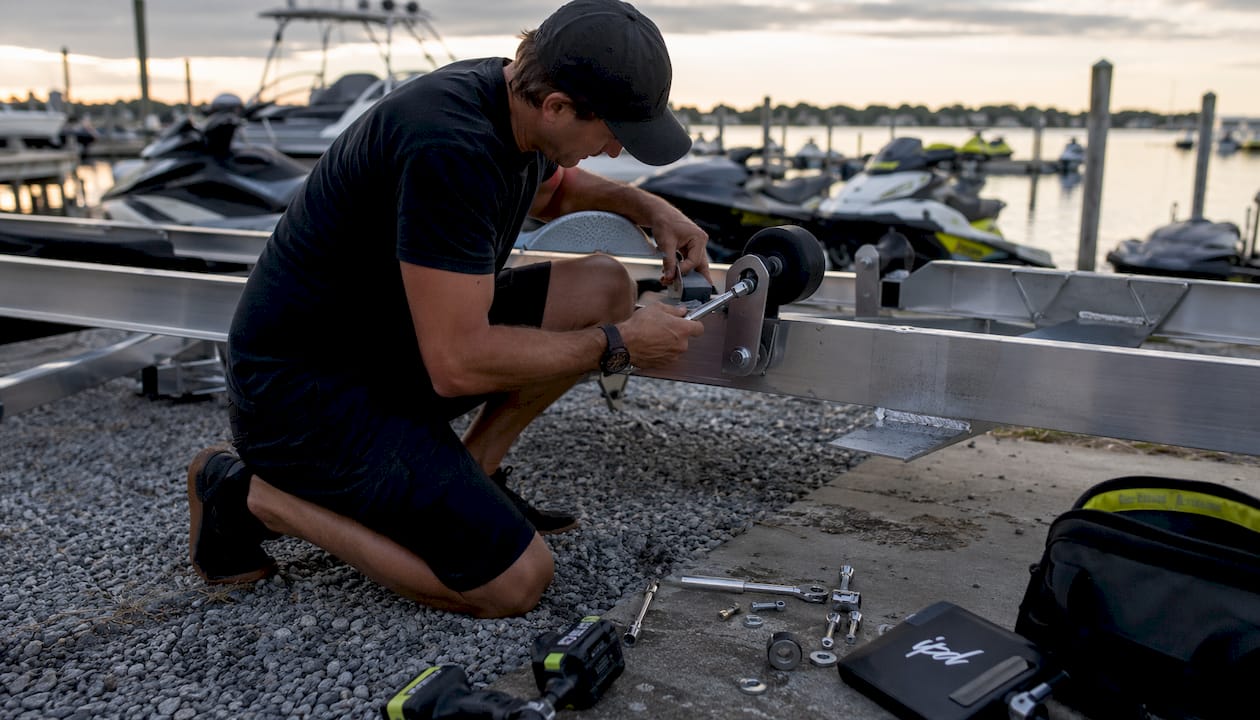 Close-up of hands installing PWC trailer guide roller