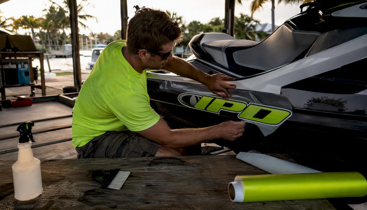 Hands installing PWC graphic with tools