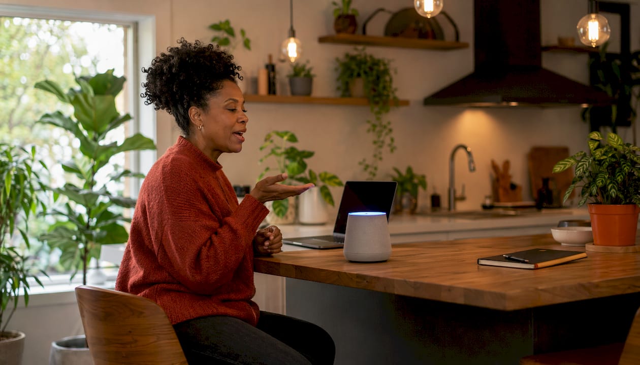 Woman interacting with smart speaker in living room